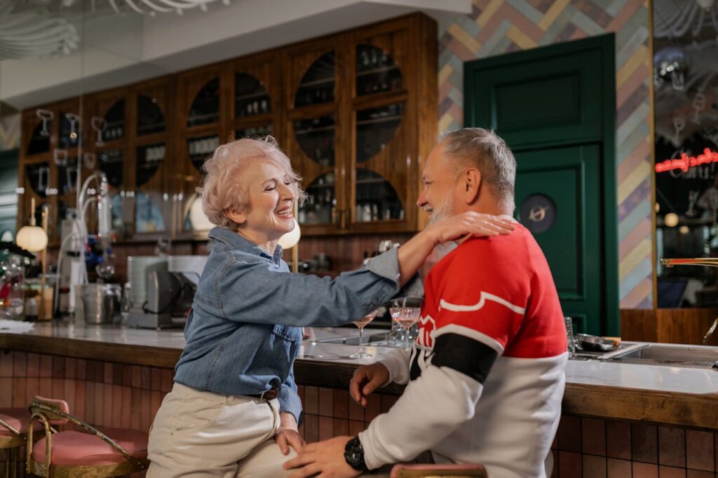 Elderly couple sharing laughter and joy in a cozy indoor café setting.